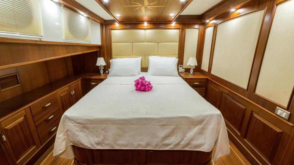 Schlafzimmer der Gulet Halcon Del Mar für zwei Personen. Sie können die Blumendekoration auf dem Bett sehen